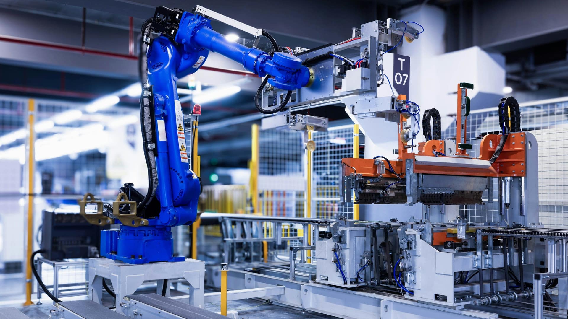 Bras robotique bleu en opération sur une ligne d'assemblage industrielle