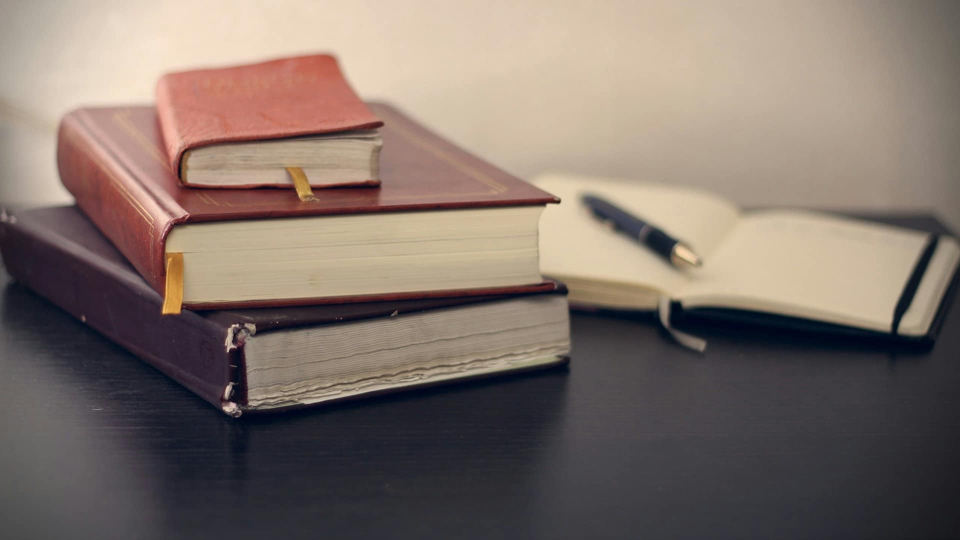 Ouvrages techniques de référence ouverts à côté d'un carnet de notes